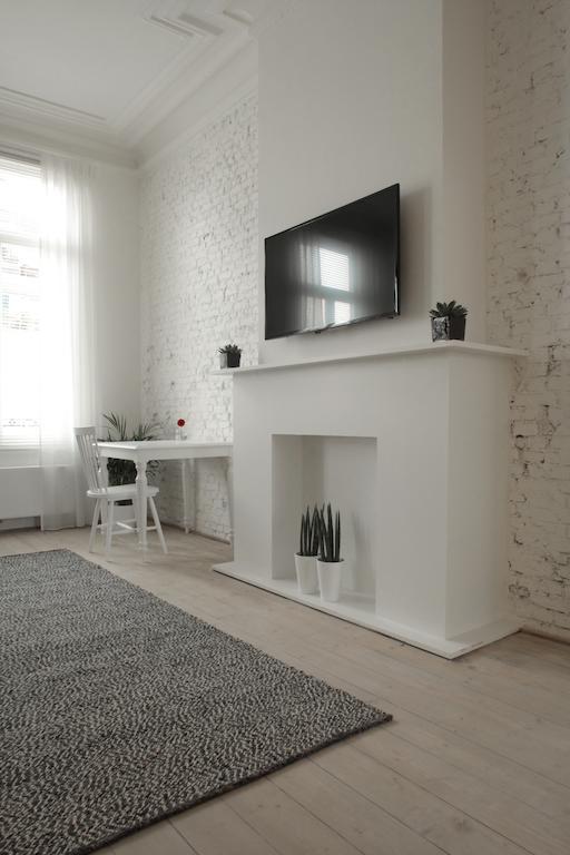 Maison Nationale City Flats & Suites Antwerpen Rom bilde A fireplace with a TV above it
